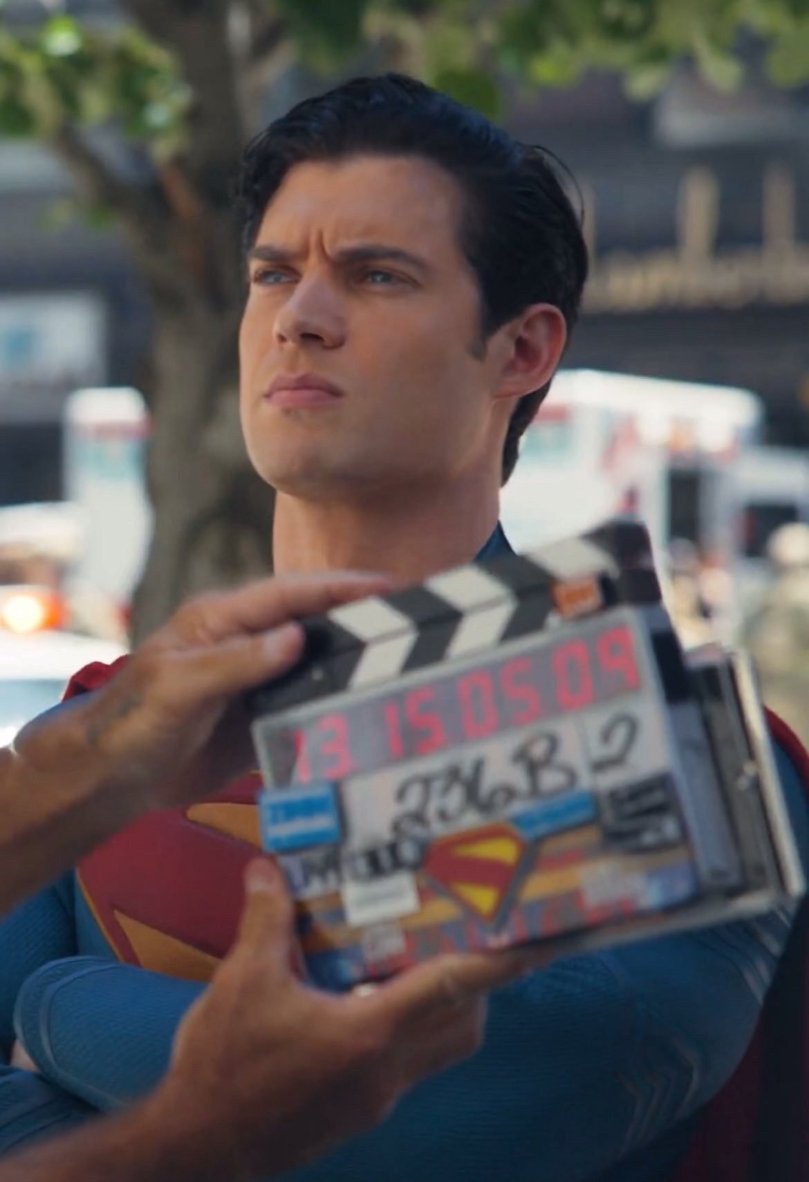 David Corenswet as Superman on the set of Superman (2025), holding a clapperboard.