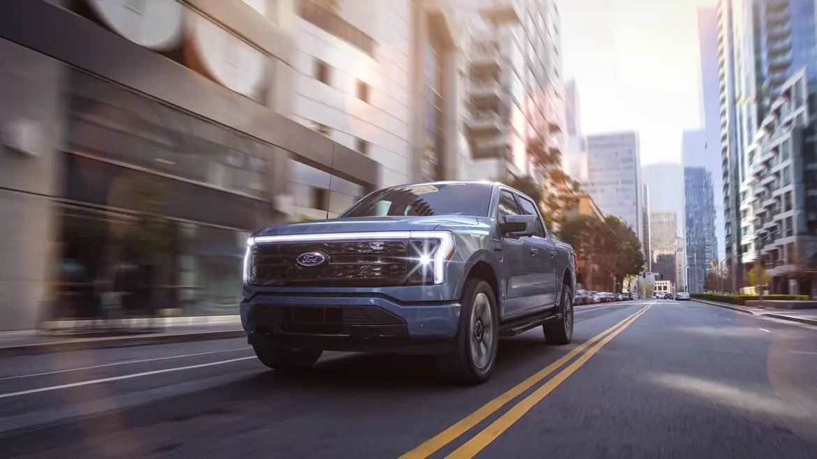 A blue F-150 Lightning on a city street