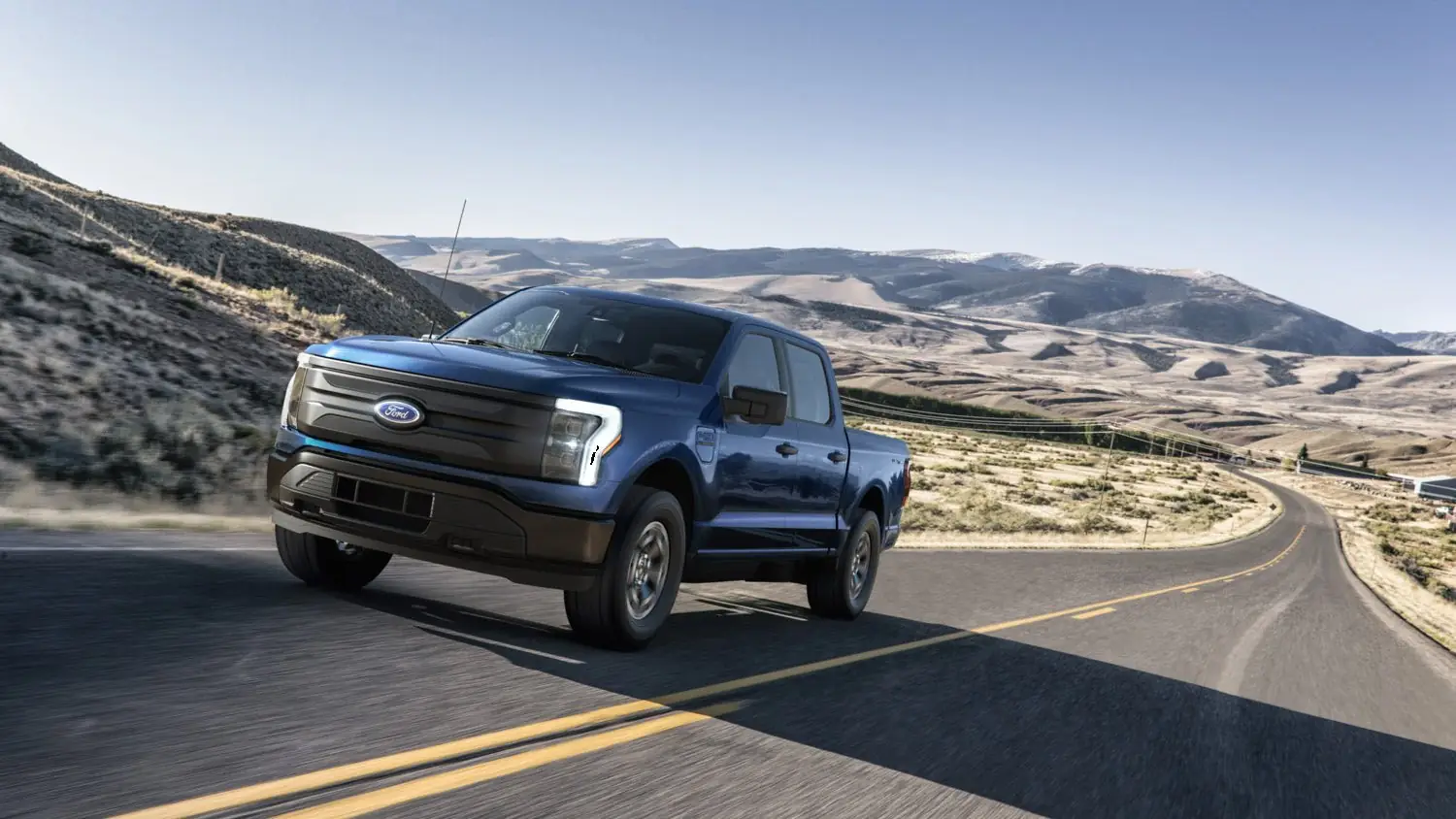 A blue F-150 Lightning on a desert highway