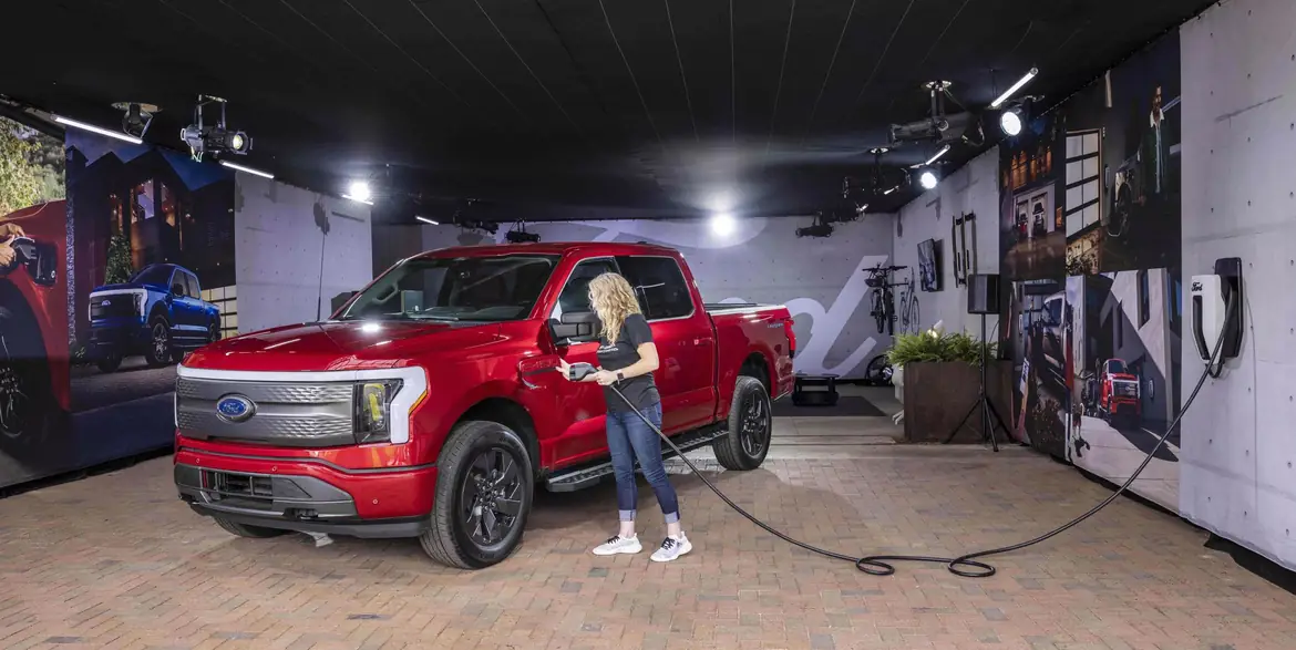 A red F-150 Lightning charging in a showroom