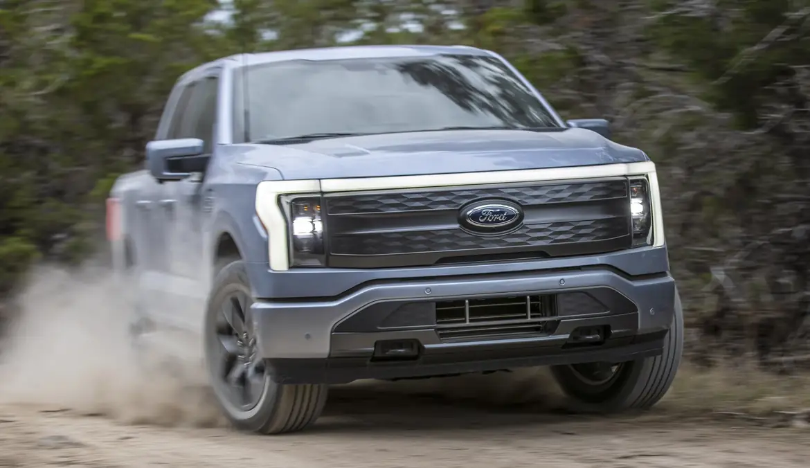 An F-150 Lightning driving through dust, head-on