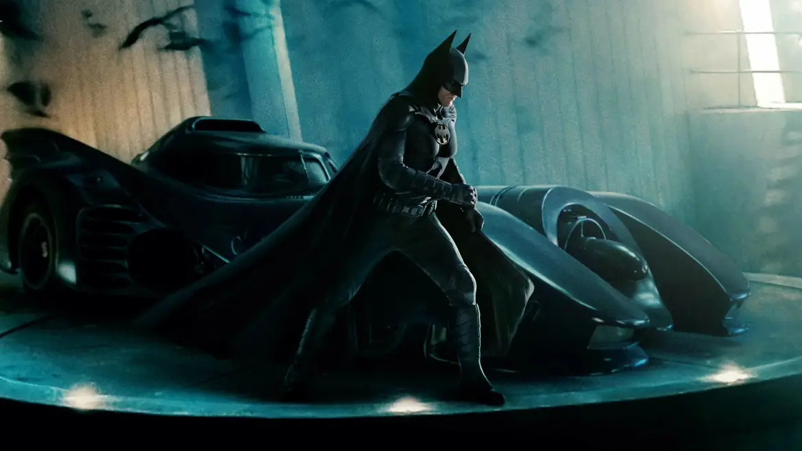 Batman beside the Batmobile