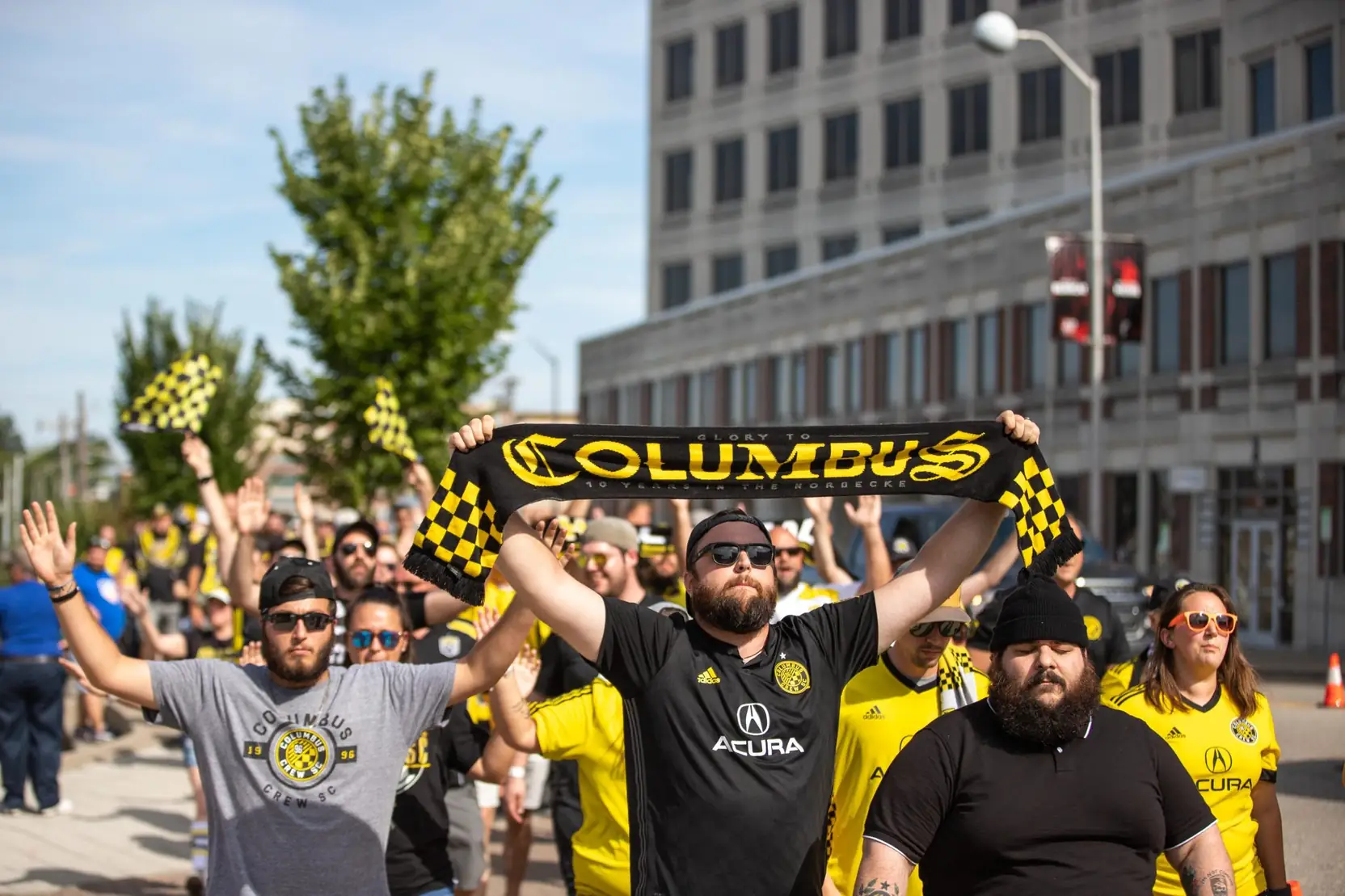Crew supporters marching with scarves raised