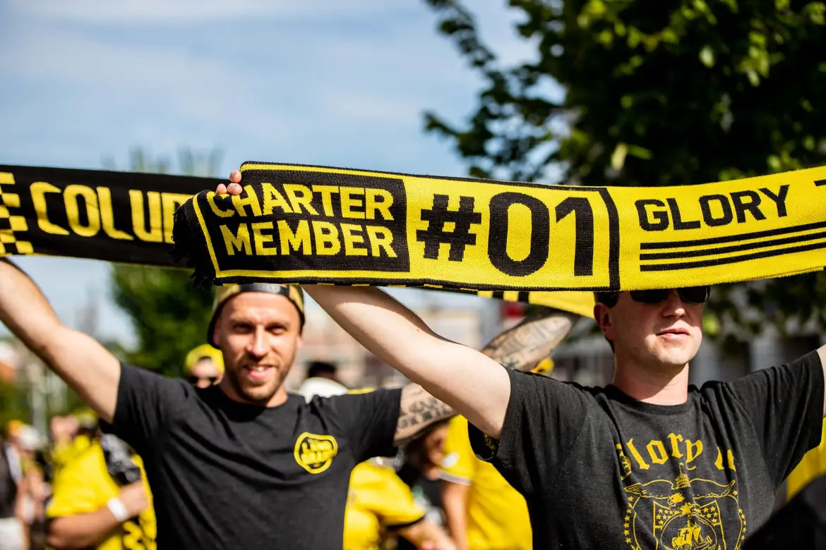 Supporters holding a charter member scarf