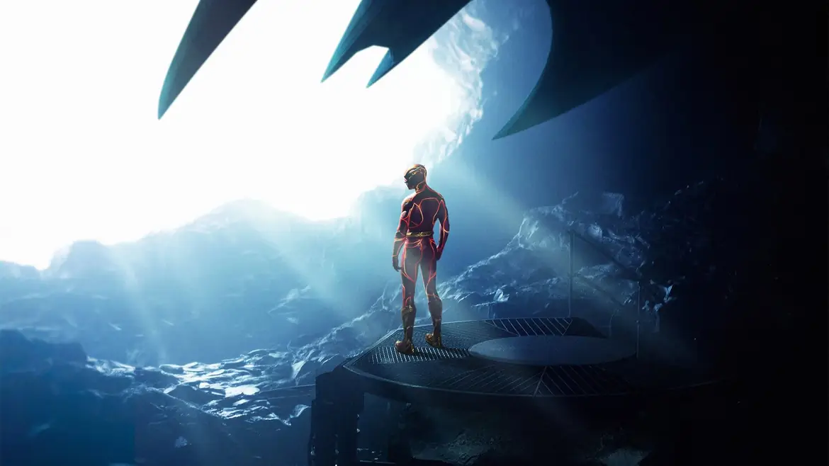 The Flash standing in the Batcave under a shaft of light